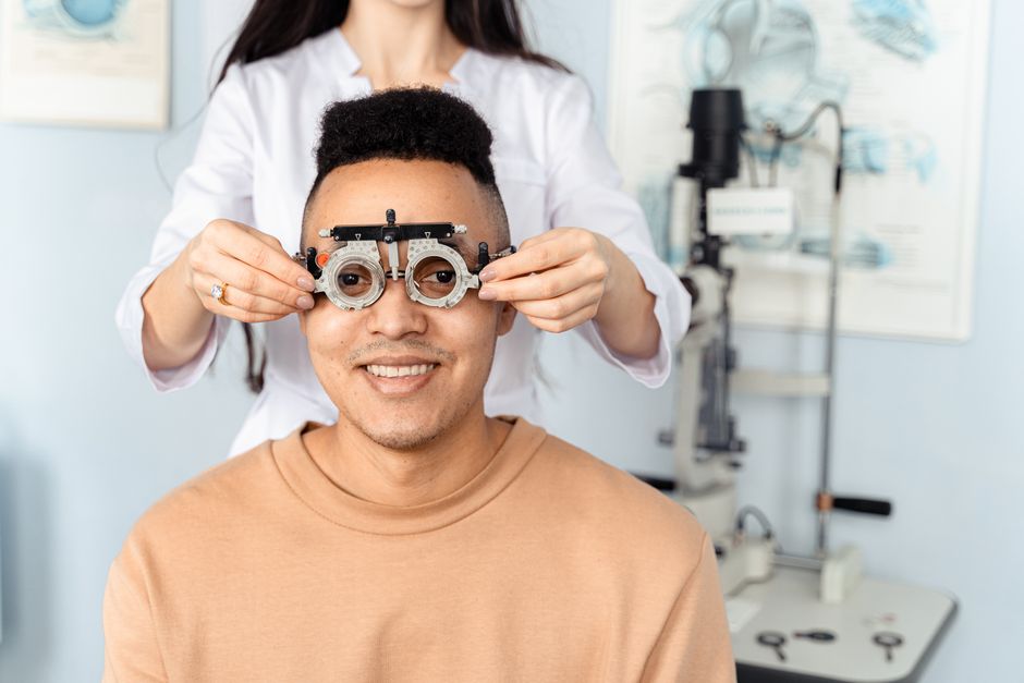 Patient undergoing a vision exam with a phoropter while researching how much does LASIK cost in 2026